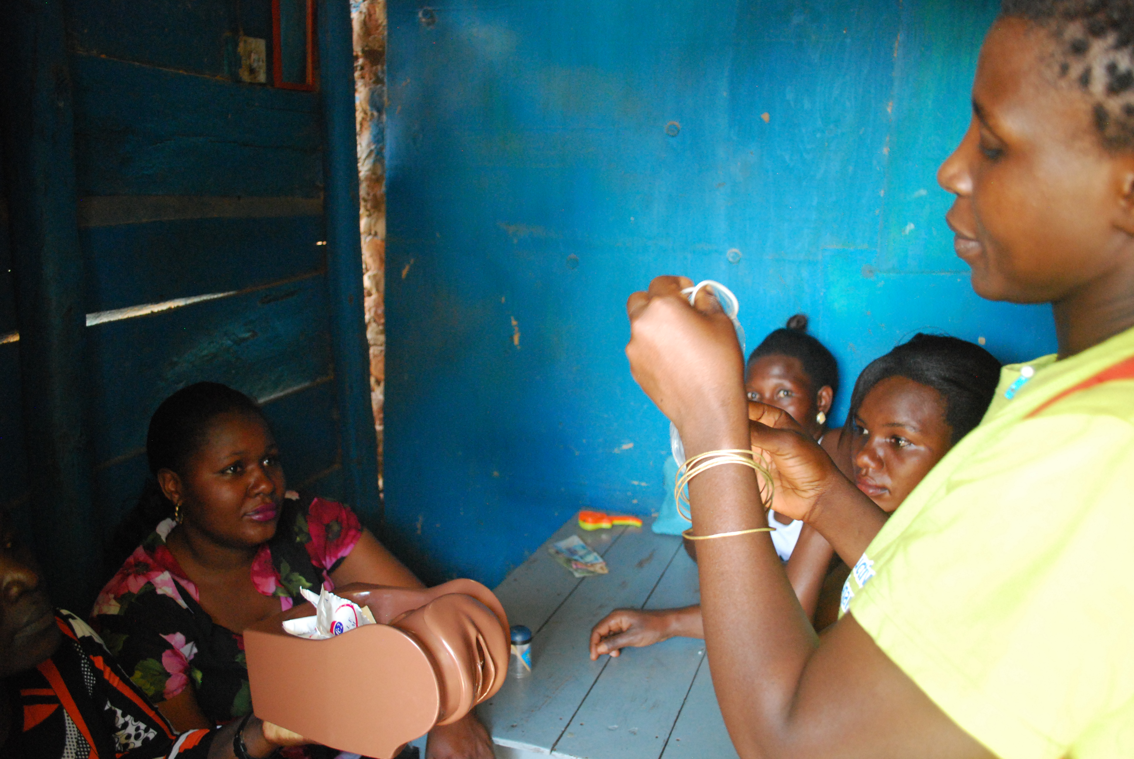 Woman shows a condom during training