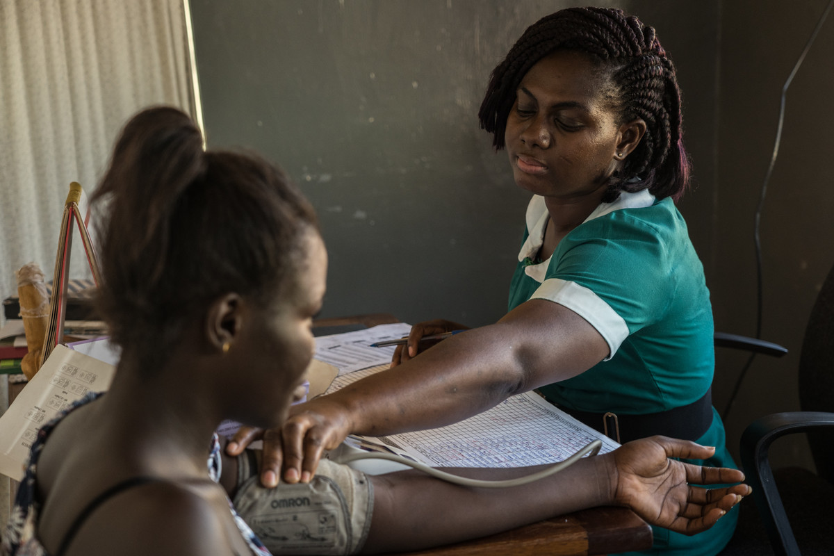 	Sophia Abrafi, Midwife , 40, checks blood pressure of her patient Jennifer Osei at the Mim Health Centre