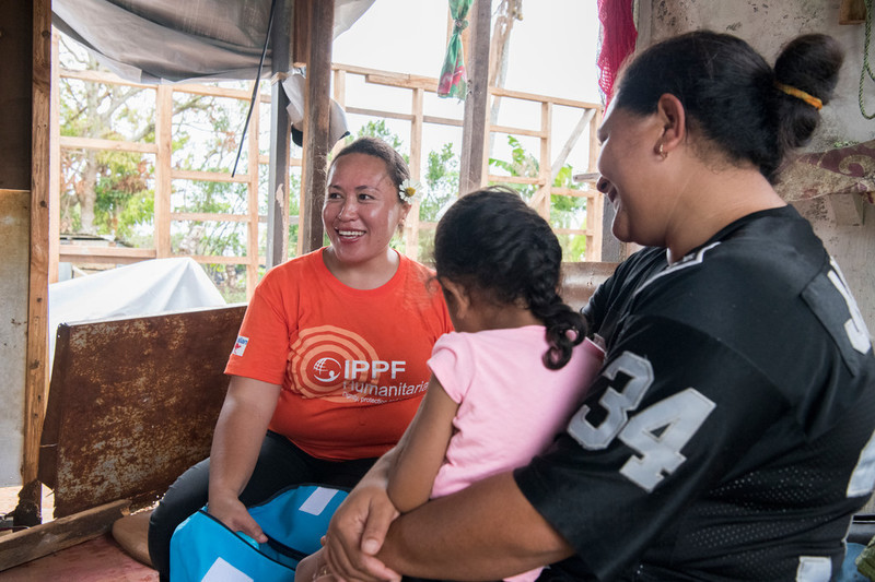 Katherine Mafi gives a dignity kit to Etka on Eua who lost her home in the cyclone.