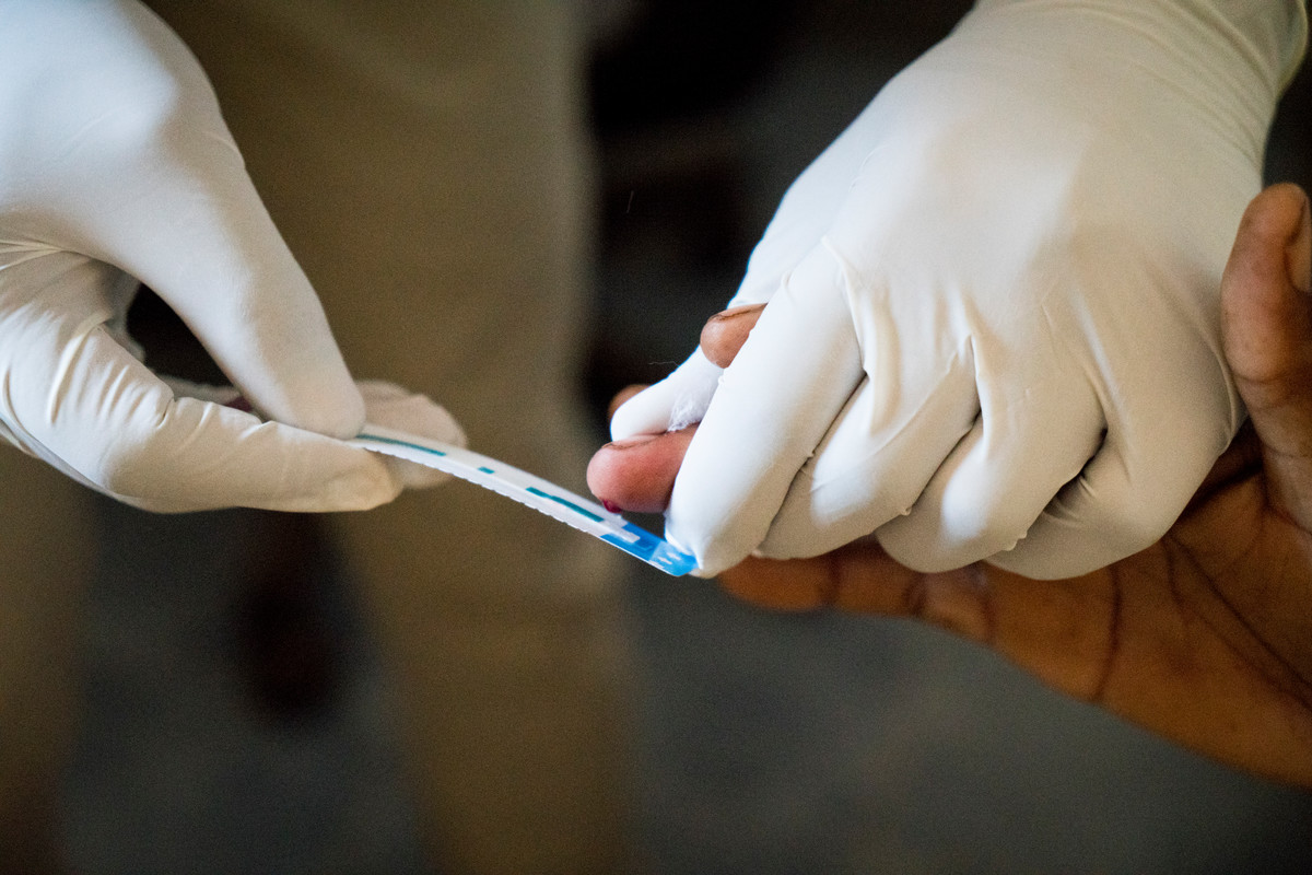 A patient gives blood for a rapid HIV test at the laboratory in The Family Care Medical Centre (FHOK) in Kibera, Nairobi, Kenya