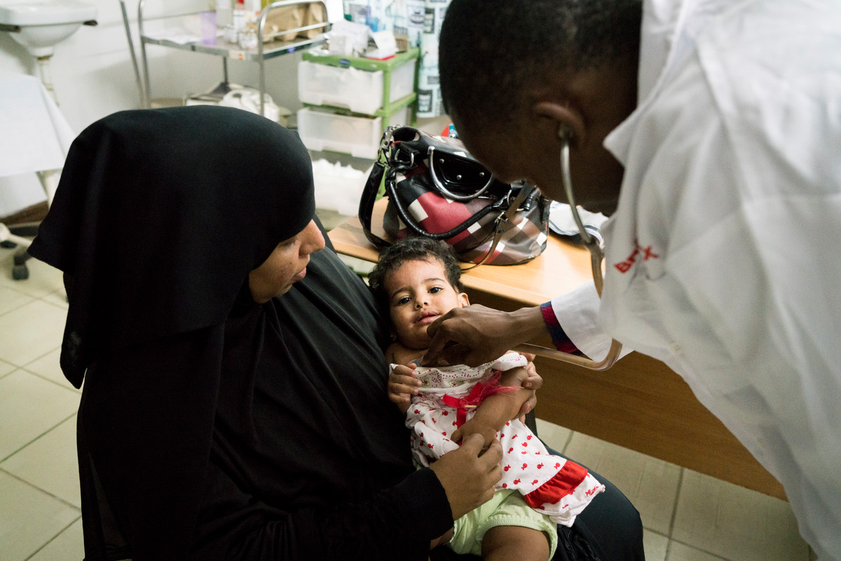 Clinical Officer Adillahi Ali, checks baby Fatma as she sits with her mother Anisa, at The Family Care Medical Centre (FHOK) in Malindi, Kenya