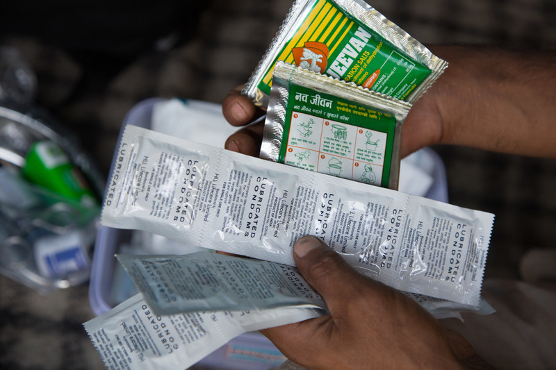 Hand holding packs of condoms