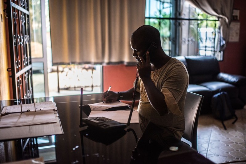 Ali Kikongo, a program officer with Little Mermaids Bureau, takes a call on the sex-workers hotline at the LMB office in Kampala, Uganda.