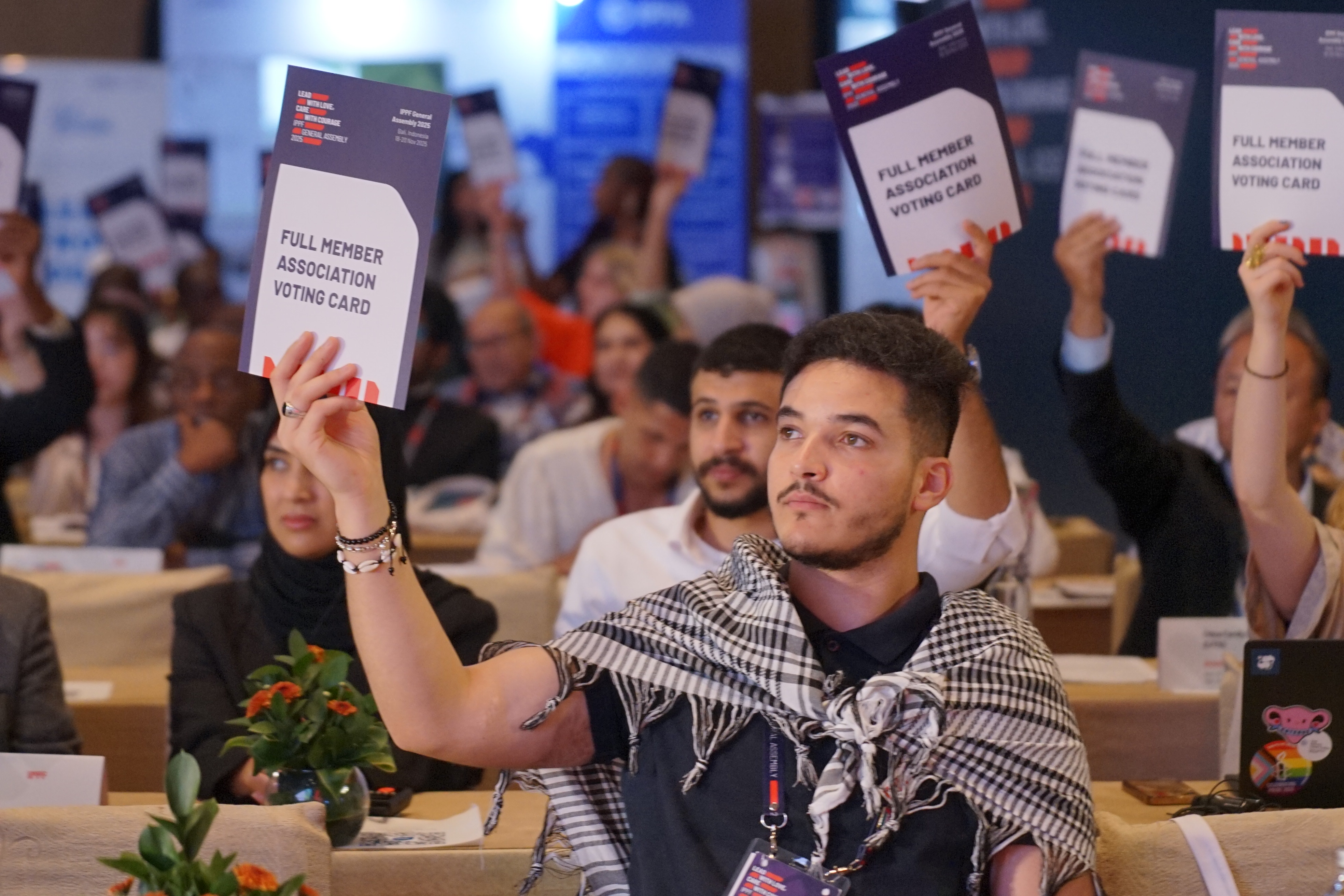 A man holds up a voting card at the IPPF General Assembly
