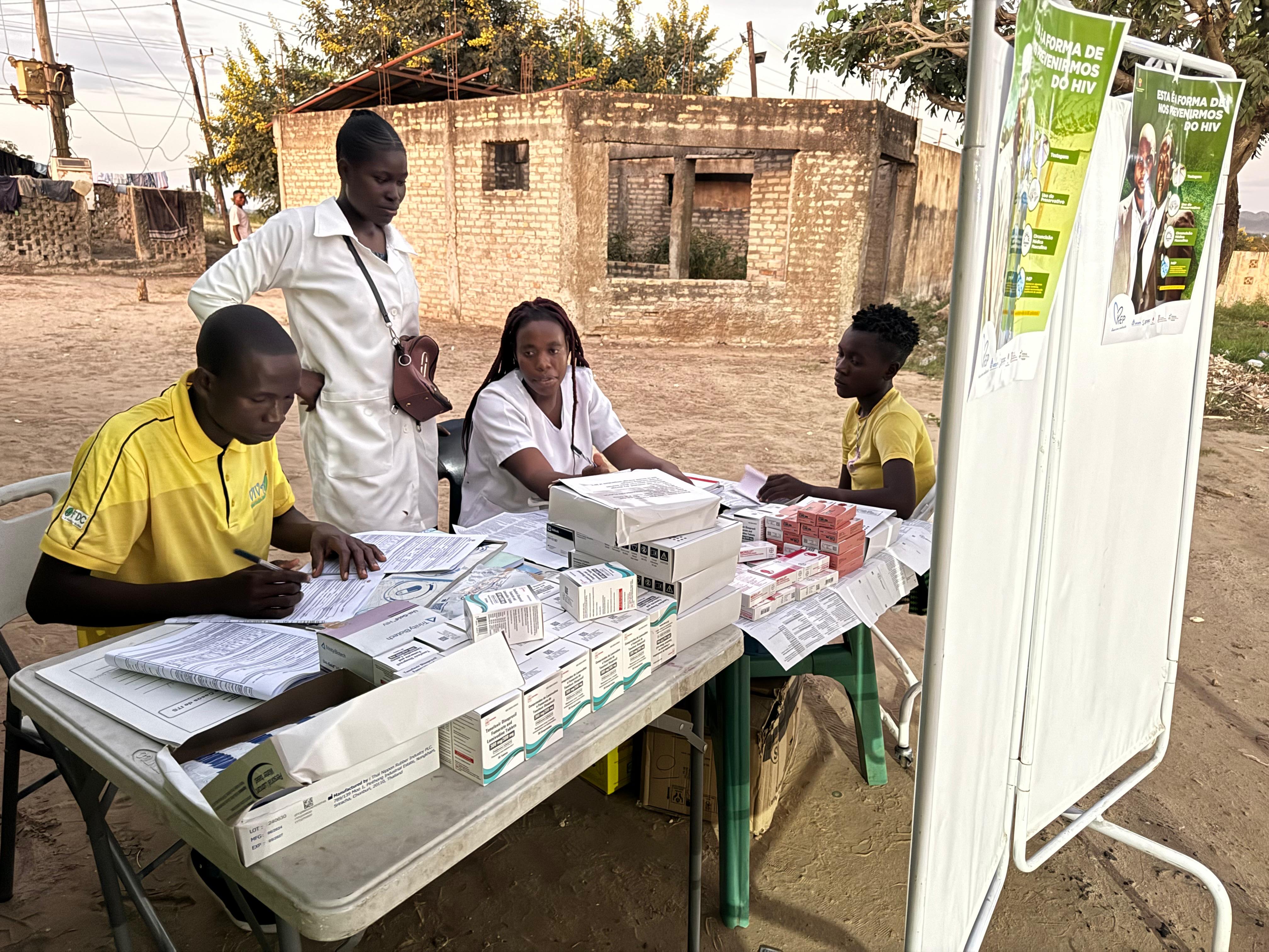 Four people gather round an HIV testing clinic
