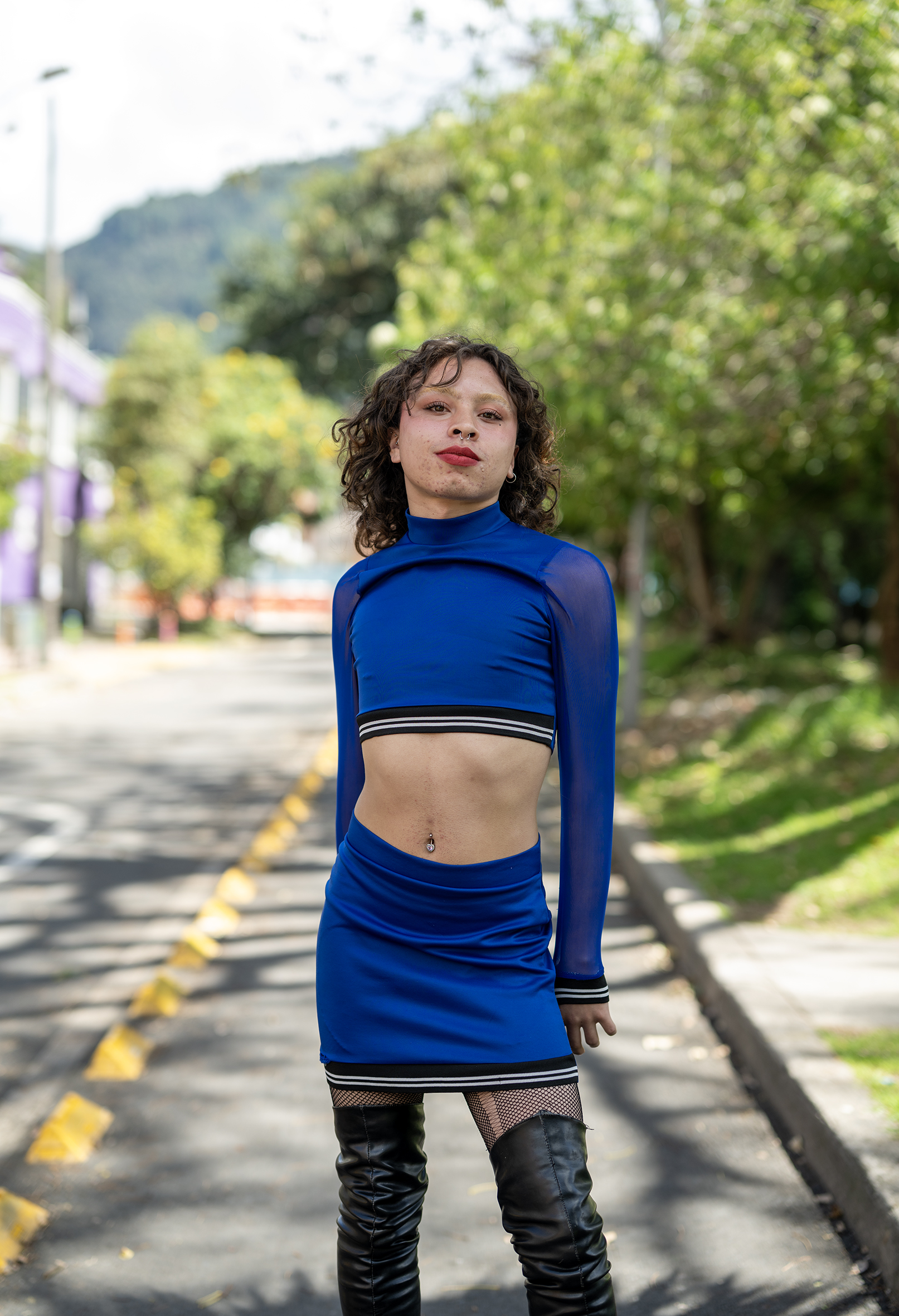 Dominica stands proud straight on to the camera in a blue dress