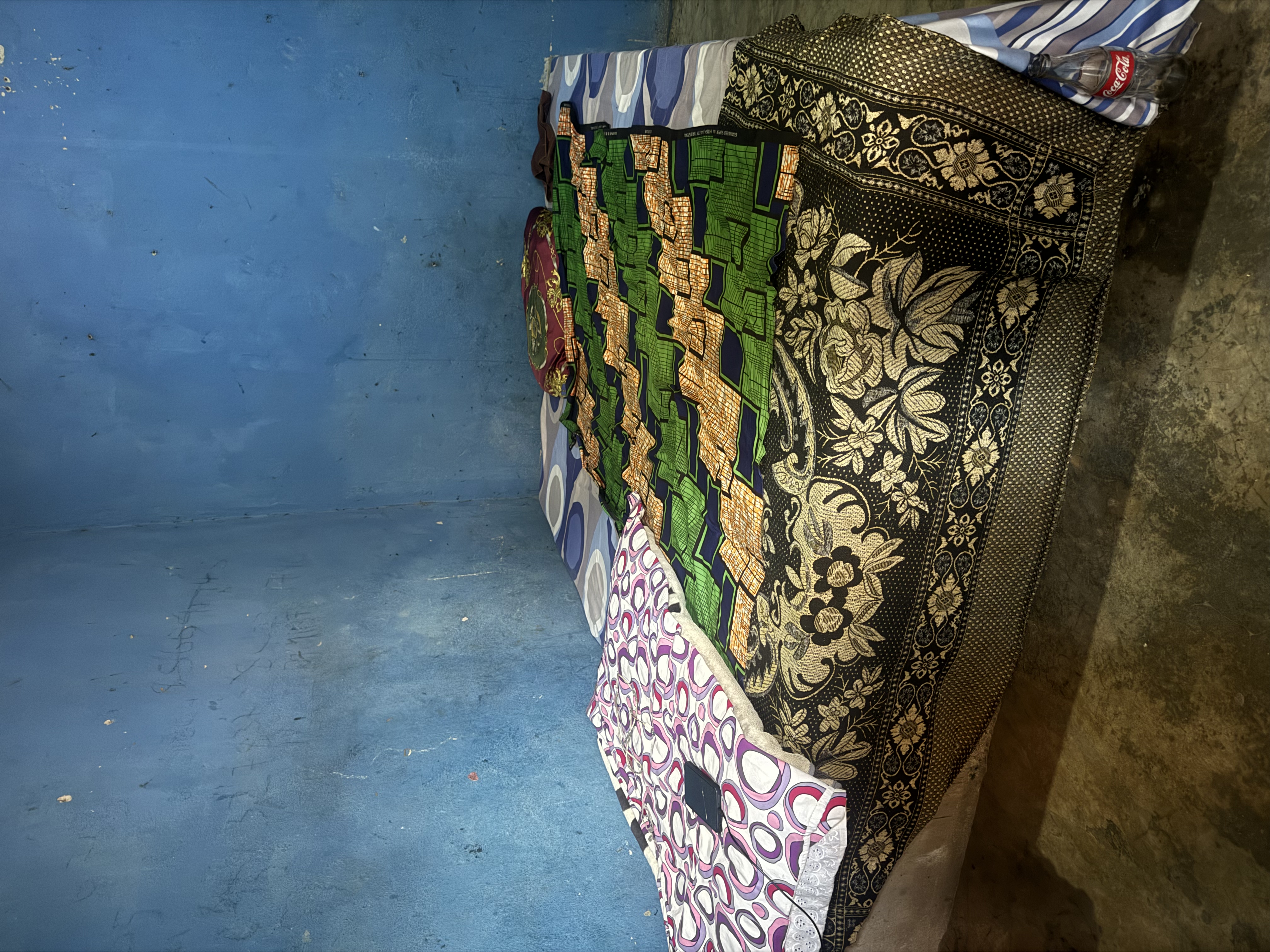 A picture of a bed with blue walls in the background. 