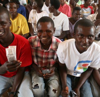 Group of young men. One holds condoms. 
