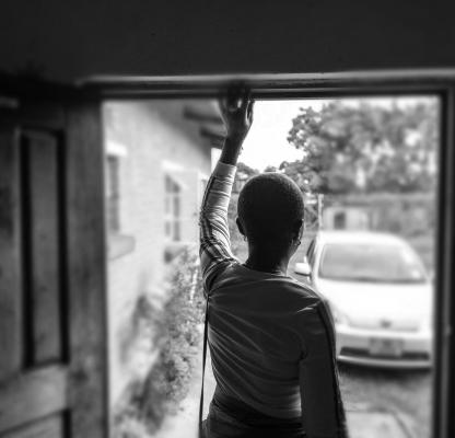 woman stand in door way - black and white