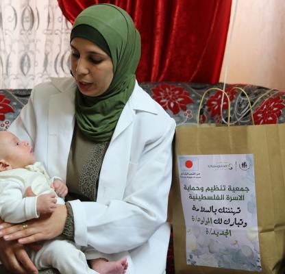 mother and baby receive goods in Palestine