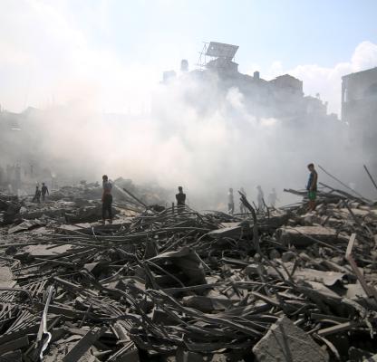 People stand on the rubble of a bombed building in Palestine