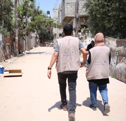 A man and a woman walk down an empty street in Gaza