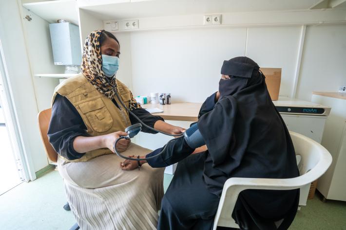 A health care professional tests a patients blood pressure at a mobile clinic in Sudan.
