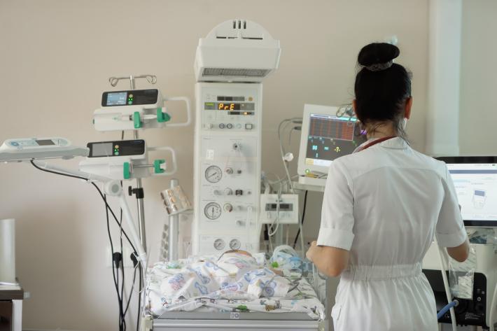 A healthcare professional monitors a newborn baby in a health centre in Ukraine