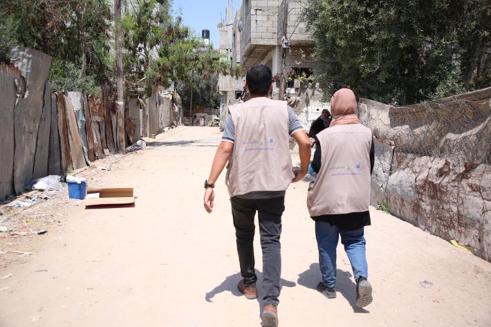 A man and a woman walk down an empty street in Gaza