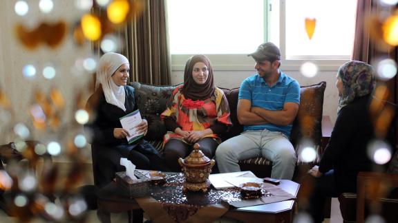 A young couple sit with a counseller