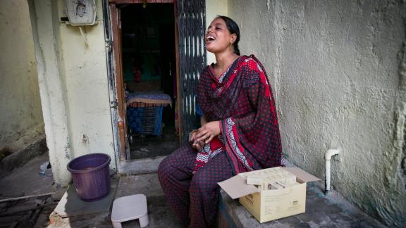 Hasina, a sex worker and peer educator sits outside a brothel, India