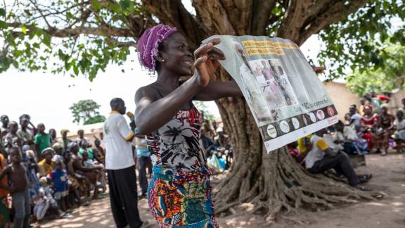 volunteer holds a family planning poster, Togo