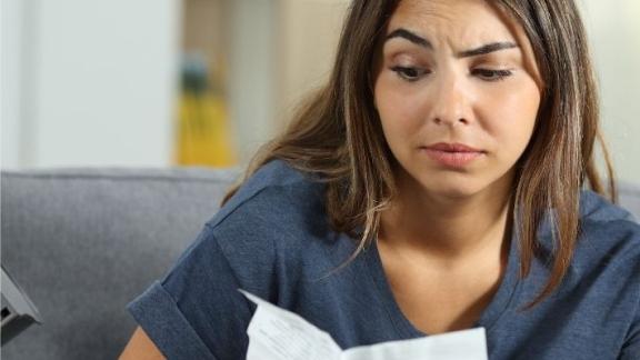 A confused-looking woman reads a leaflet