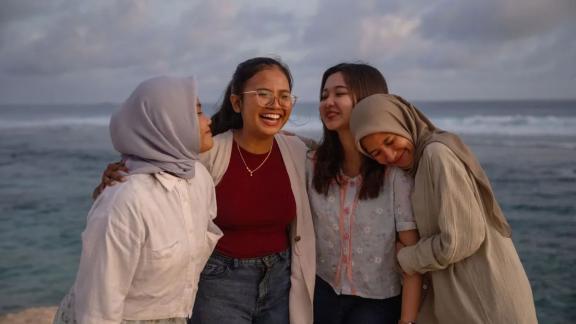 Four women in Indonesia stand together smiling. 