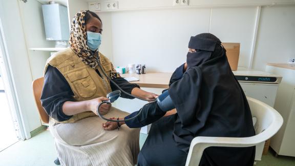 A health care professional tests a patients blood pressure at a mobile clinic in Sudan.