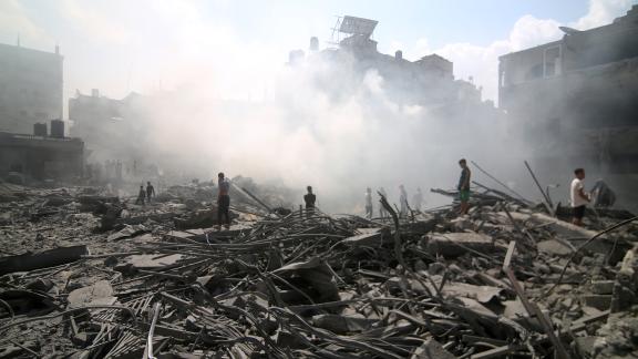 People stand on the rubble of a bombed building in Palestine