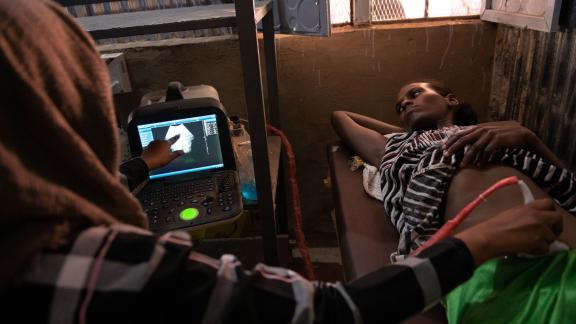 A healthworker conducts an ultrasound in a refugee camp