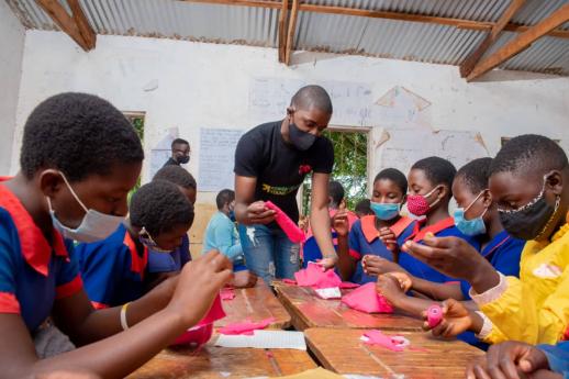 Peter Mndalasini training primary school girls how to make reusable sanitary pads